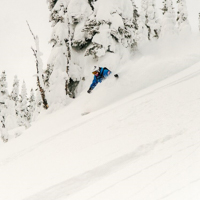 Downhill skier racing through soft powder snow