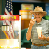 Smiling gentleman eating popcorn at an American Bank branch