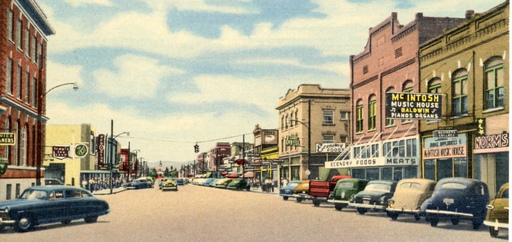 Historic street view of downtown Kalispell with cars lining the street.