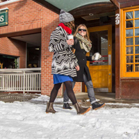 Main street store front with two women walking and talking.